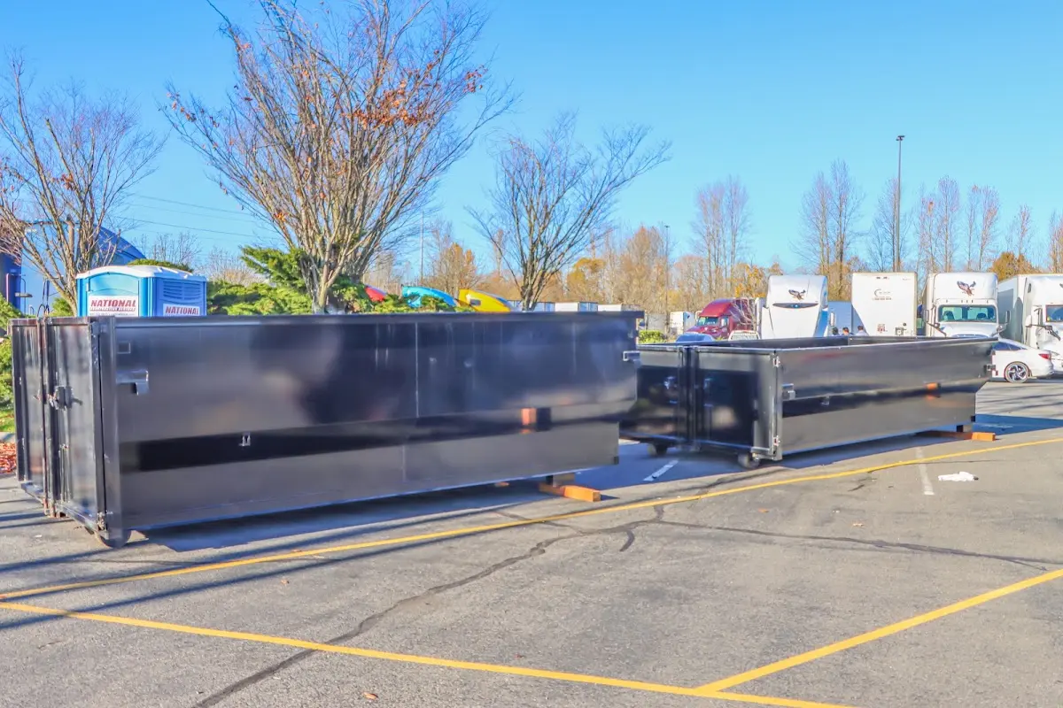 Professional dumpster rental service with roll-off container on residential driveway in Desert Palms